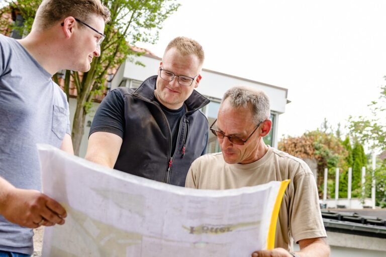 Mitarbeiter von Kötter Garten- und Landschaftsbau besprechen mit Geschäftsführer Lukas Kötter den Plan einer Außenanlage